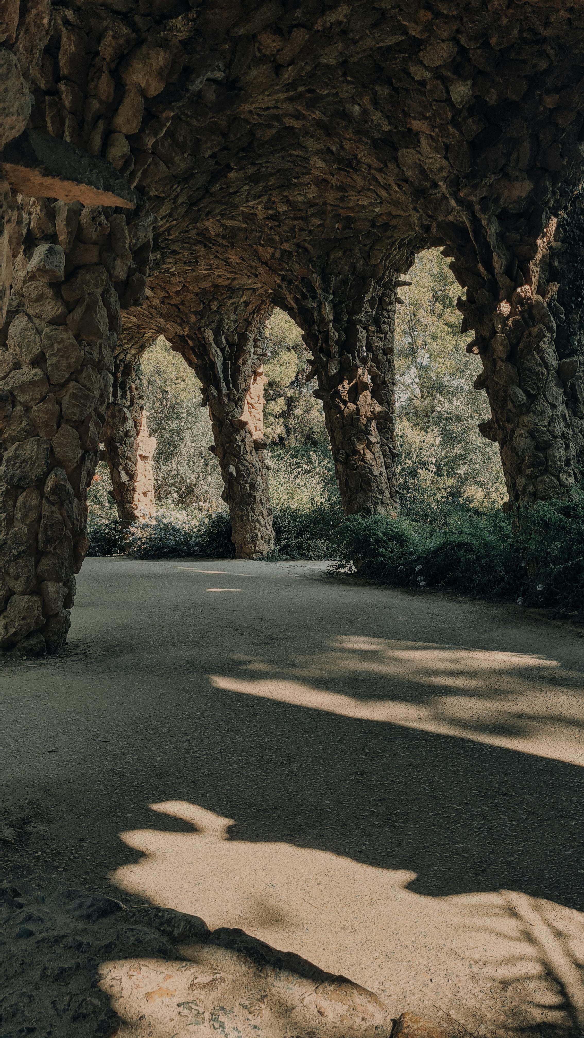 footpath with rocks colonnade in park guell in barcelona