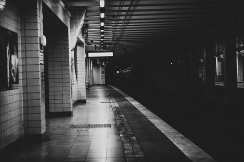 Free An atmospheric black and white photo of an empty urban metro platform at night. Stock Photo