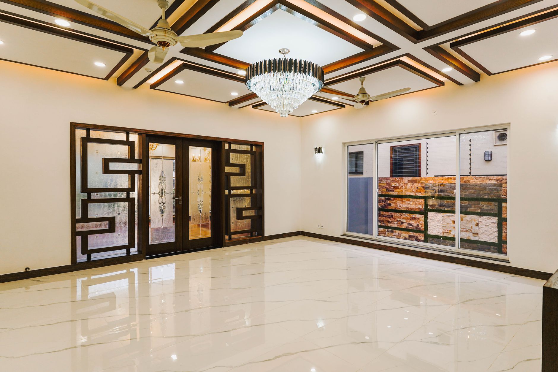Spacious luxury room with ornate doors and marble flooring.