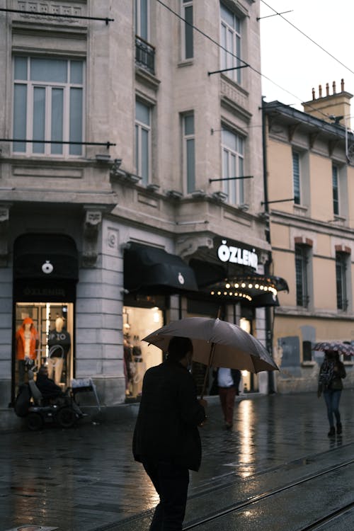 People with Umbrellas Walking in City 