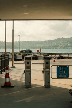 Serene harbor view featuring ferry terminal gates and distant cityscape across the sea.