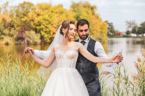 Newlyweds Standing Together by Lake