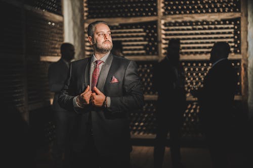 Man in Suit Standing with People behind at Winery