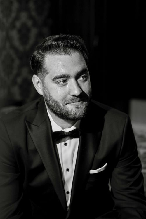 Free Black and white portrait of an adult man in a tuxedo exuding elegance and sophistication. Stock Photo