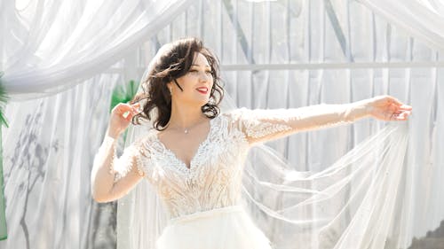 Smiling Bride in a White Wedding Dress and Veil