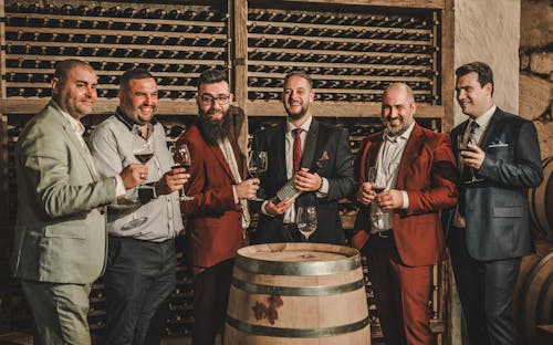 Smiling Men in Suits and with Wine at Winery