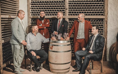 Men in Suits and Shirts Sitting at Winery