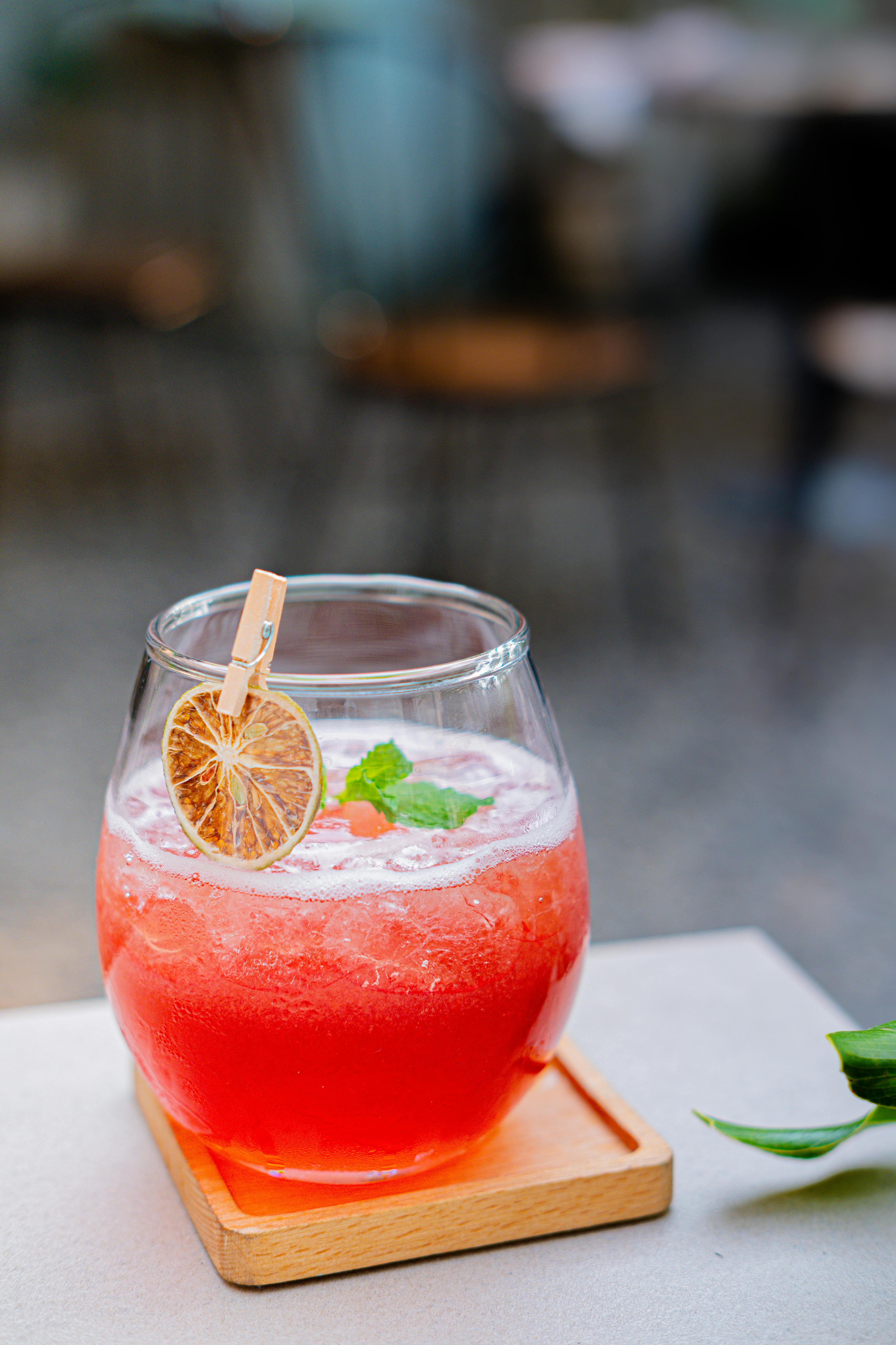 A vibrant red fruit drink with a dried citrus garnish in a glass, perfect for refreshment.