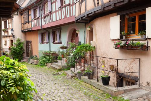 Free Picturesque cobblestone street and half-timbered houses in Eguisheim, a beautiful French village. Stock Photo