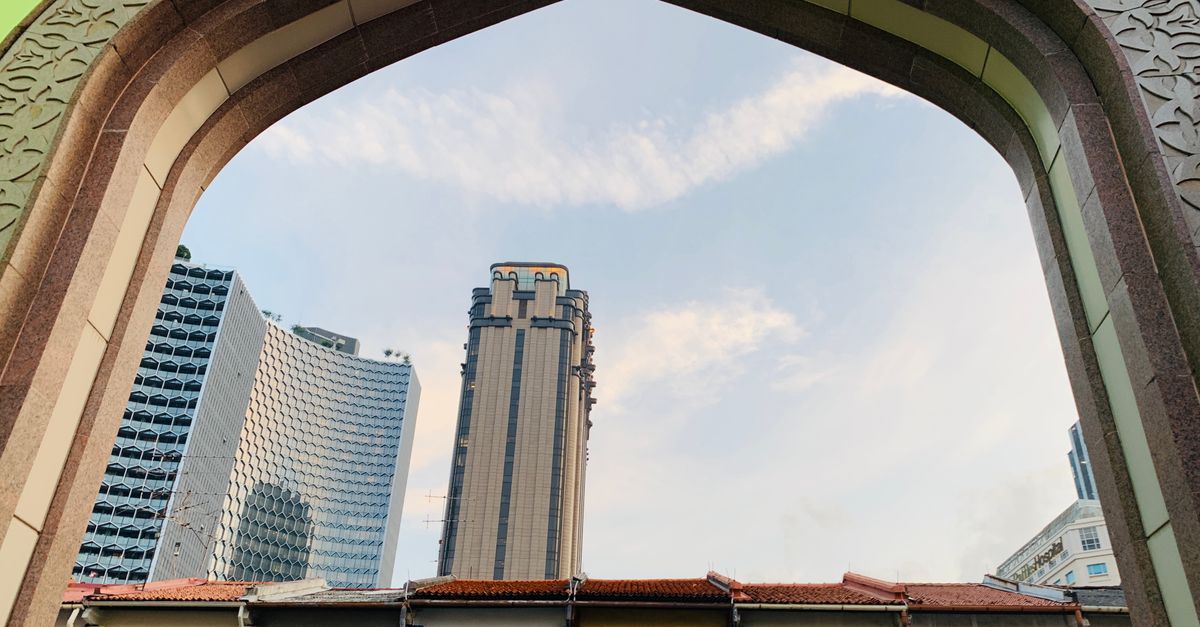 A striking view of Singapore's unique skyscrapers seen through an ornate architectural arch.