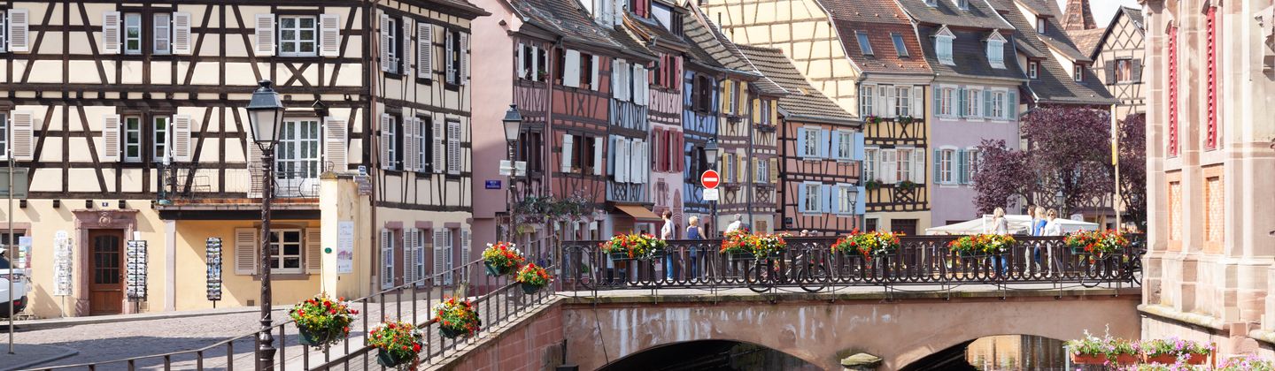 Vue pittoresque des maisons à colombages de Colmar et du pont pittoresque sur un canal paisible.