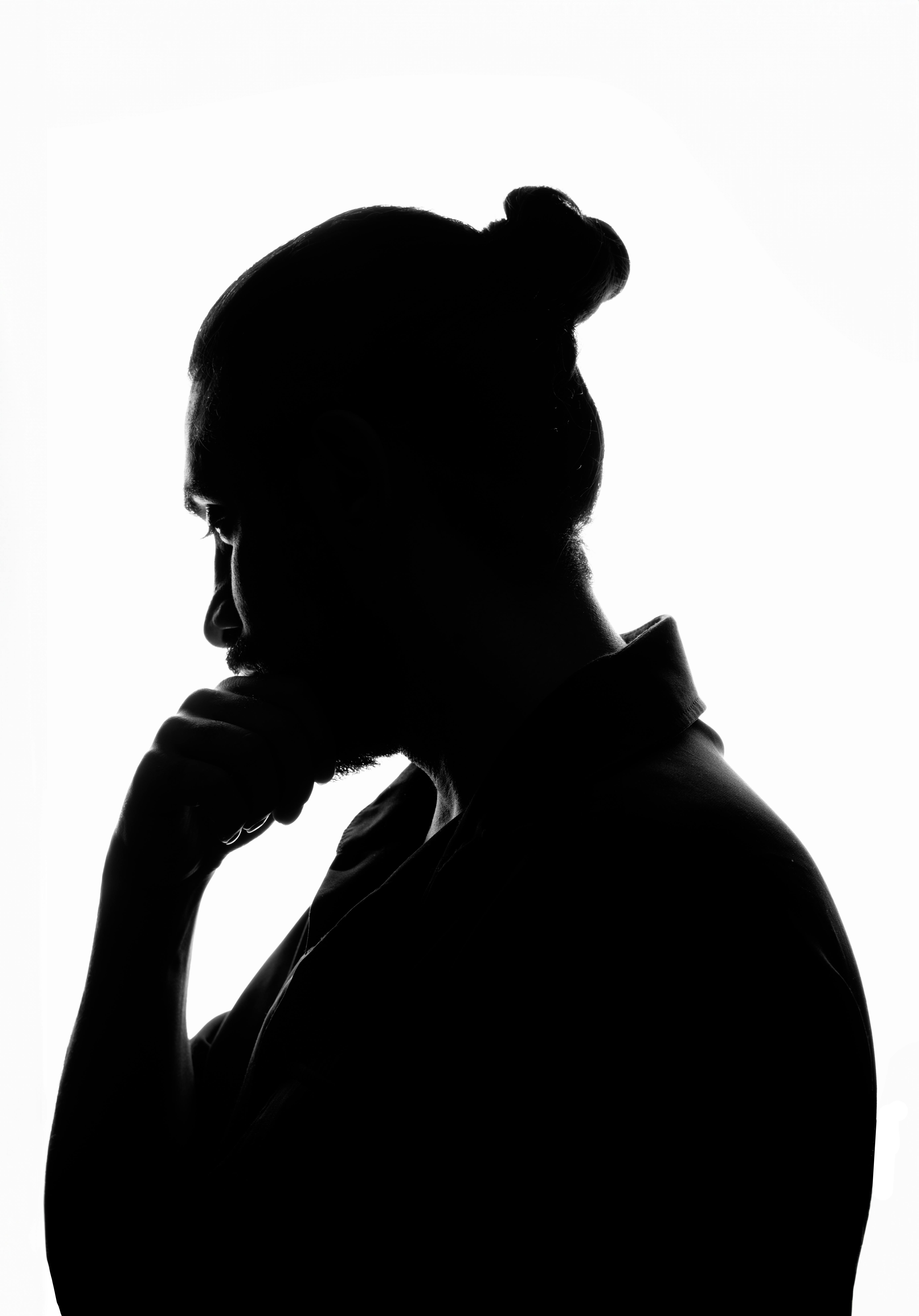 Black and white silhouette of a man thinking, hand on chin, isolated on white background.