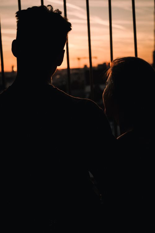 Free A couple sharing a romantic moment with a silhouette view at sunset in Munich, Germany. Stock Photo