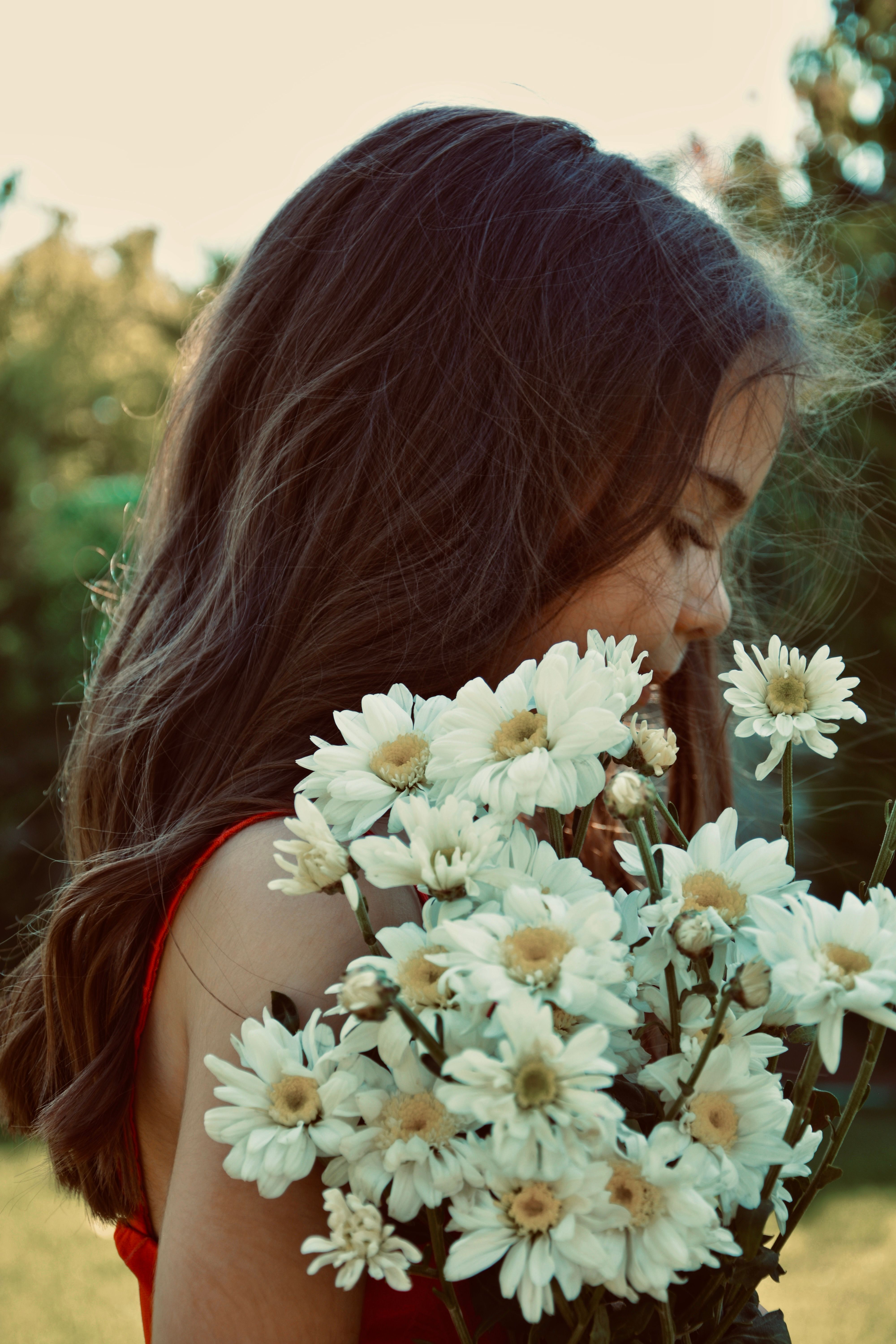 Selective Focus Photo of a Woman in a Floral Top Holding a Bunch of ...
