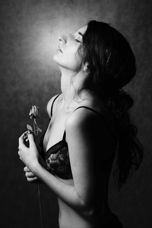 Woman in Bra Standing with Flower in Black and White