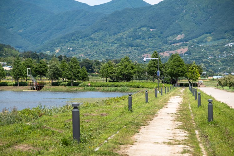 Park With Footpath And Pond In Valley