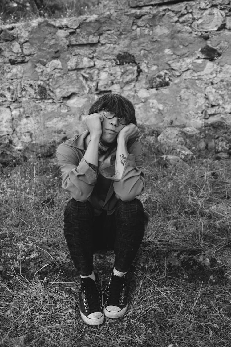 Man Sitting On Grass With Sad Face