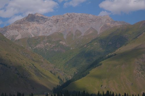Free Stunning view of a rocky mountain range with lush green valleys under a clear blue sky. Stock Photo