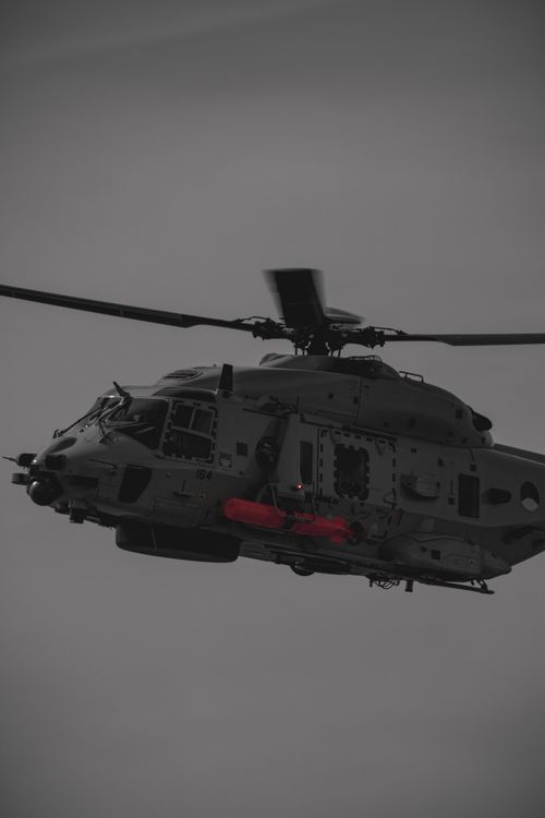 Free A powerful military helicopter flying against a grey sky in Rotterdam. Stock Photo