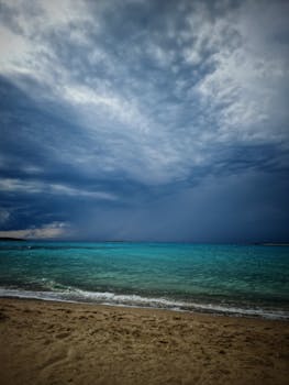 Breathtaking view of a vibrant turquoise sea under dramatic overcast skies. Ideal for backgrounds.