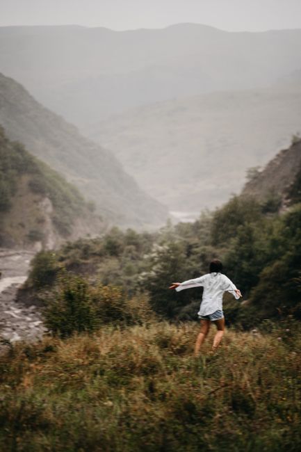 A carefree woman enjoying the lush, foggy hills of Ismailli, Azerbaijan.