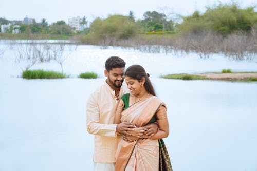 Portrait of Couple Standing in Traditional Clothing near Water