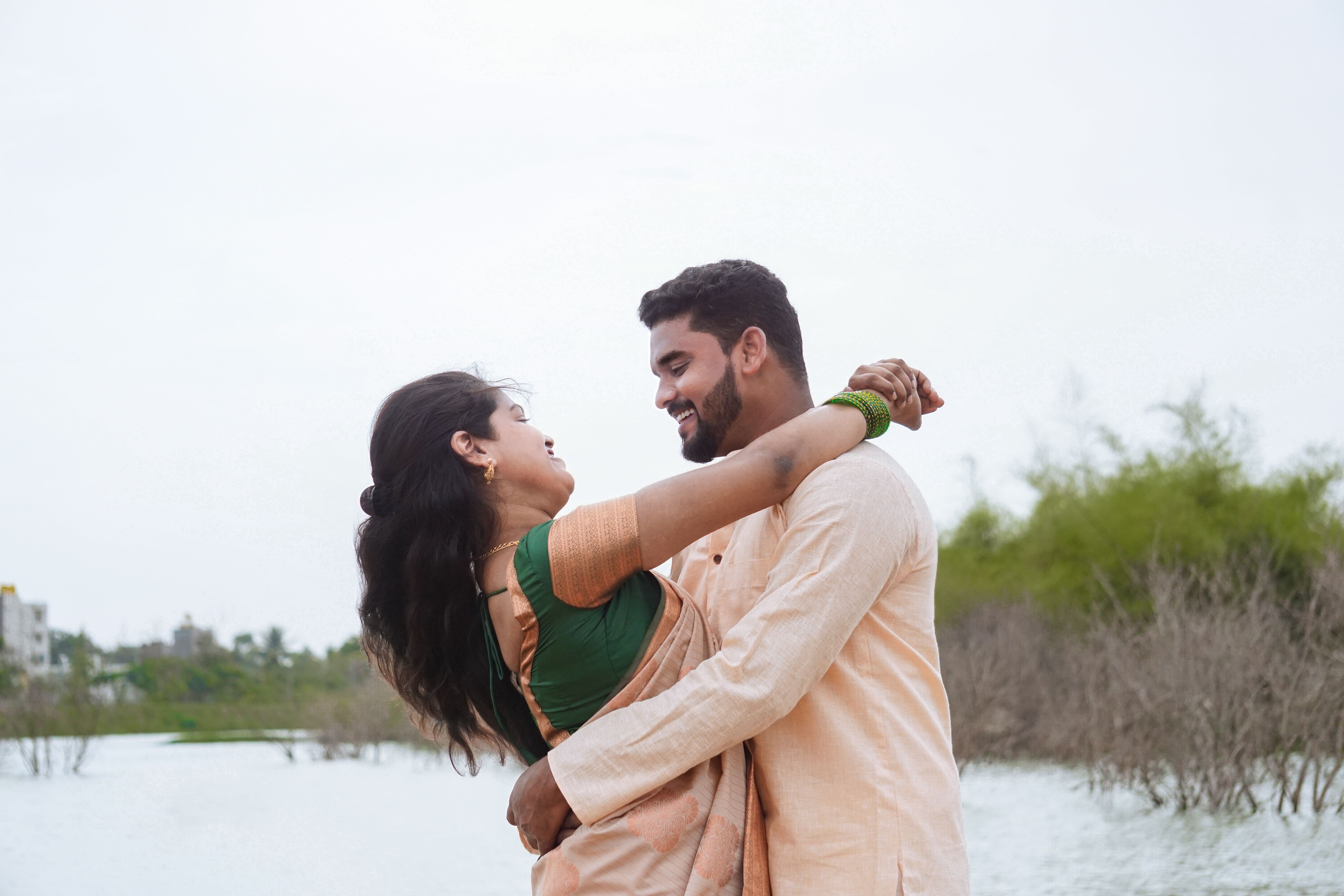 Smiling Couple in Traditional Clothing Hugging · Free Stock Photo