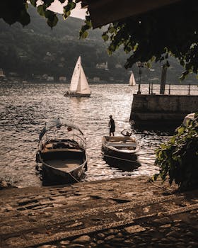 Tranquil scene of boats and sailboats on Lake Maggiore, Stresa, Italy, at sunset.