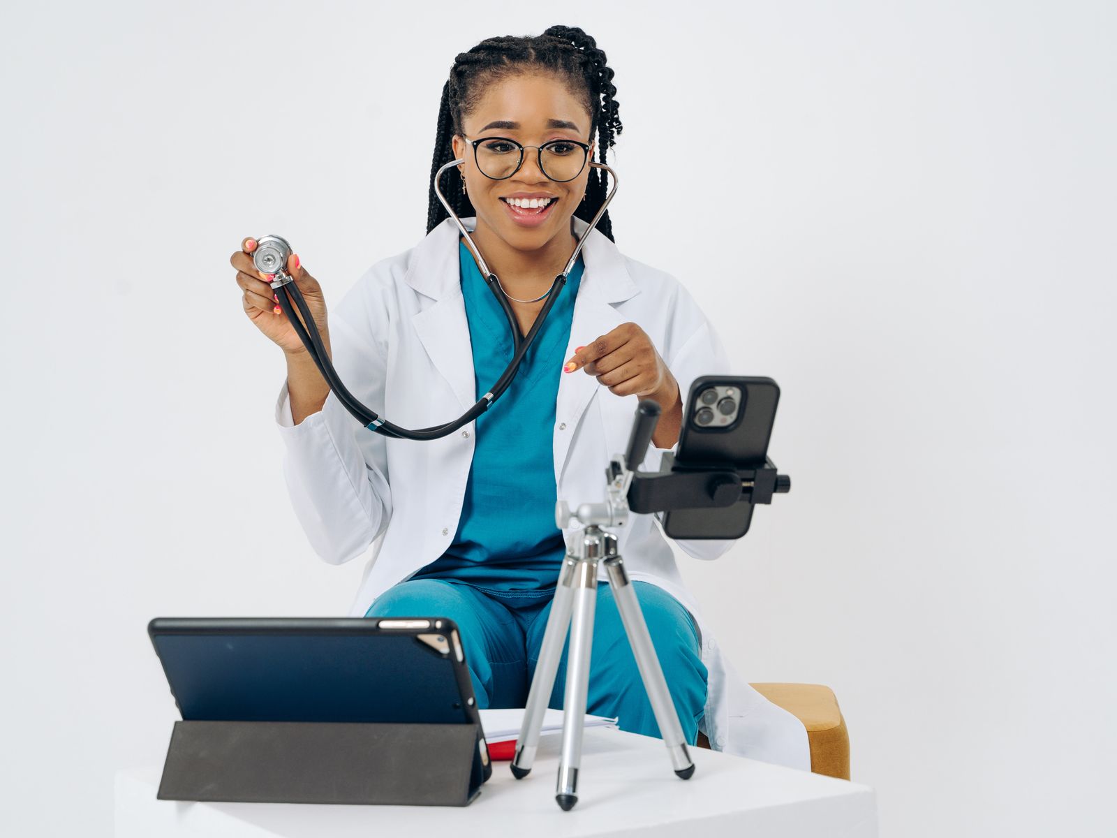 Smiling doctor using a smartphone and tablet for patient communication