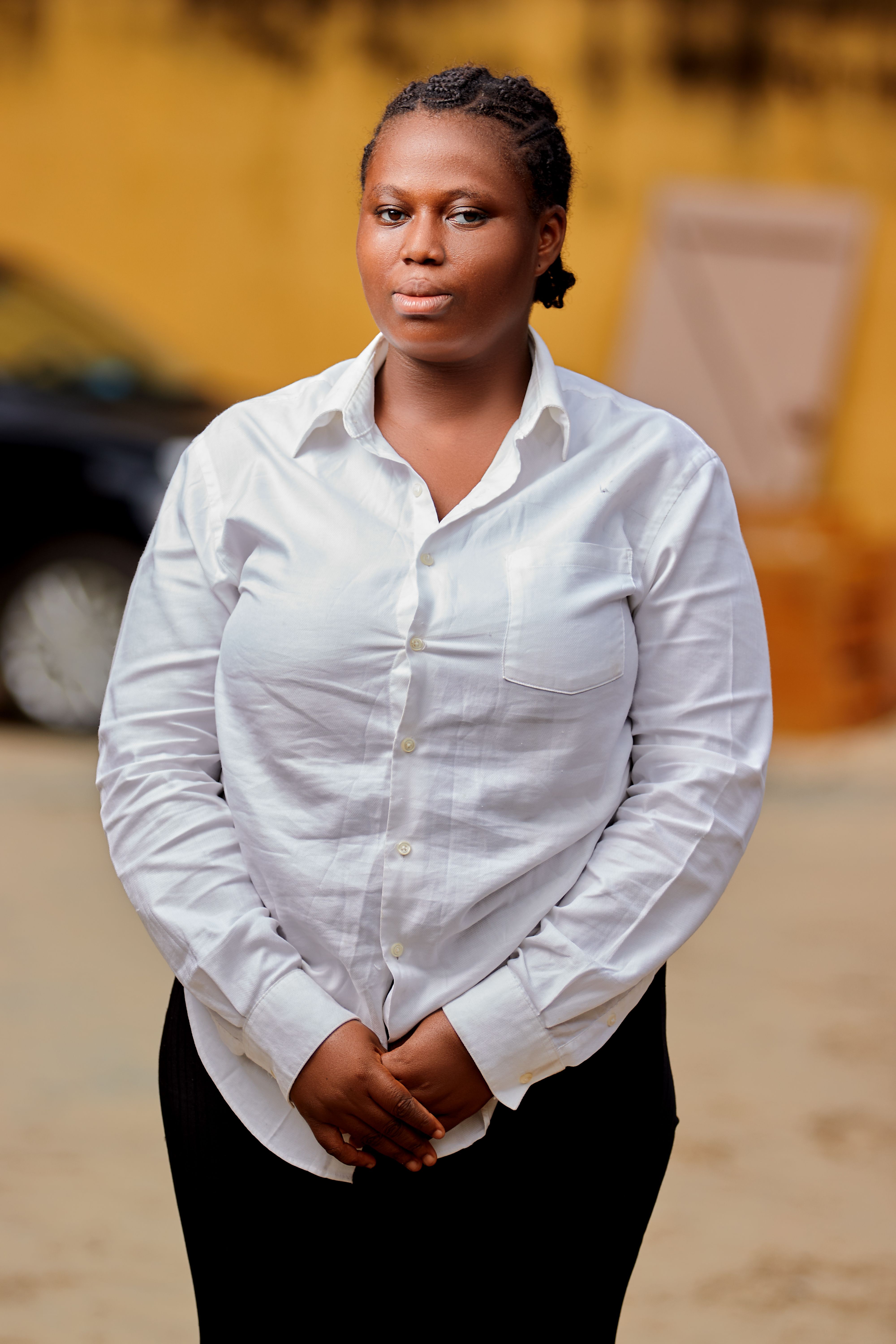 Portrait of a woman standing confidently in a white shirt, showcasing fashion and elegance.