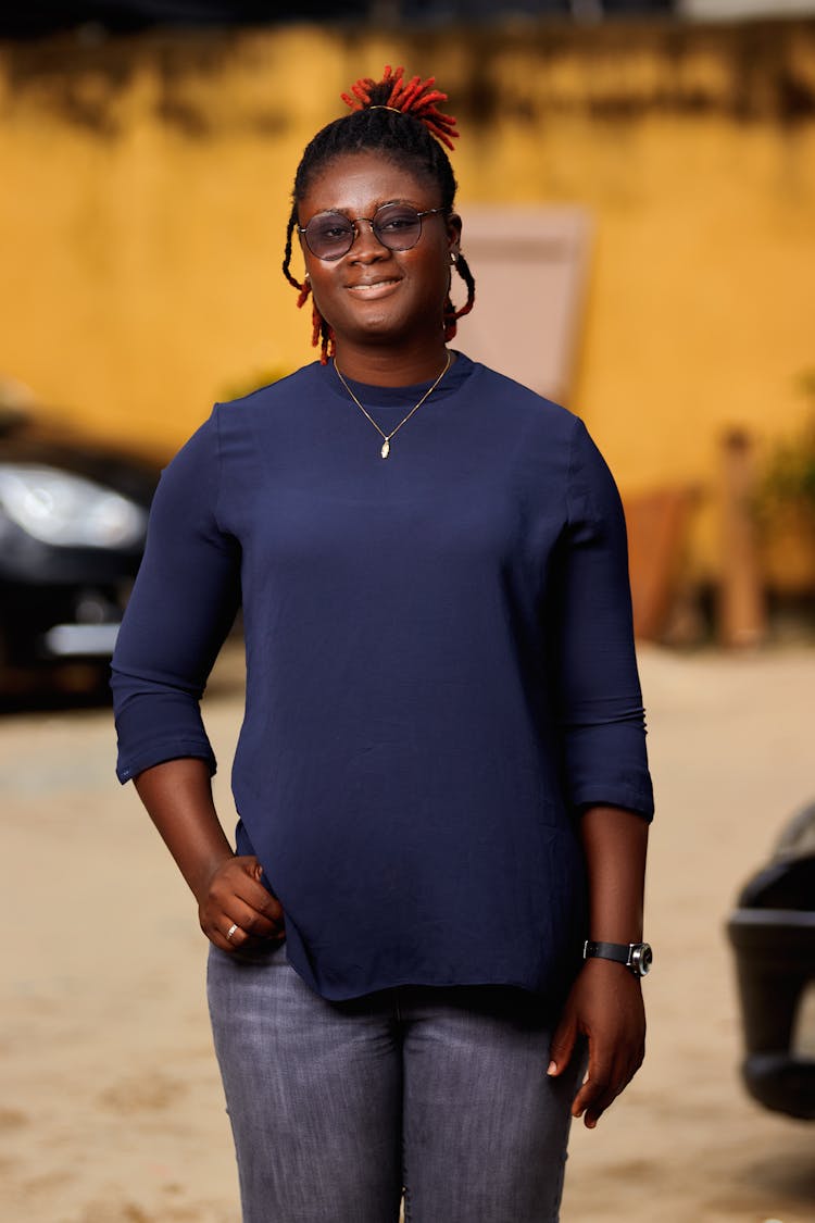 Woman In A Navy Blue Blouse And Jeans On A Dirt Road