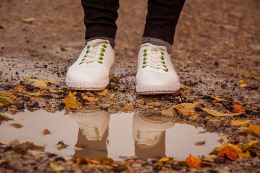 Waterproofed white shoes in the front of pothole 