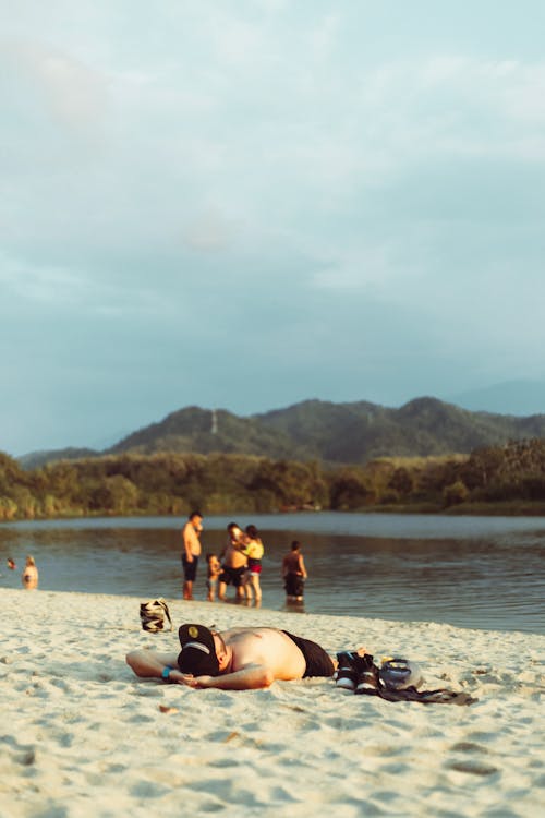 Foto profissional grátis de areia, boné, deitando-se