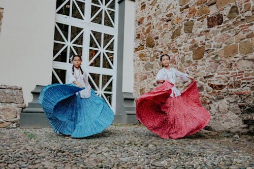Women Wearing Traditional Outfits Dancing on a Street