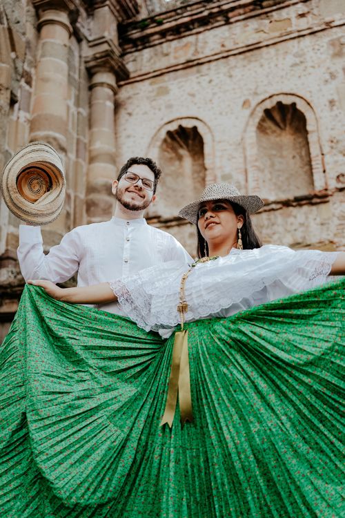 Free A cheerful couple dressed in traditional folklore attire, dancing outdoors. Stock Photo