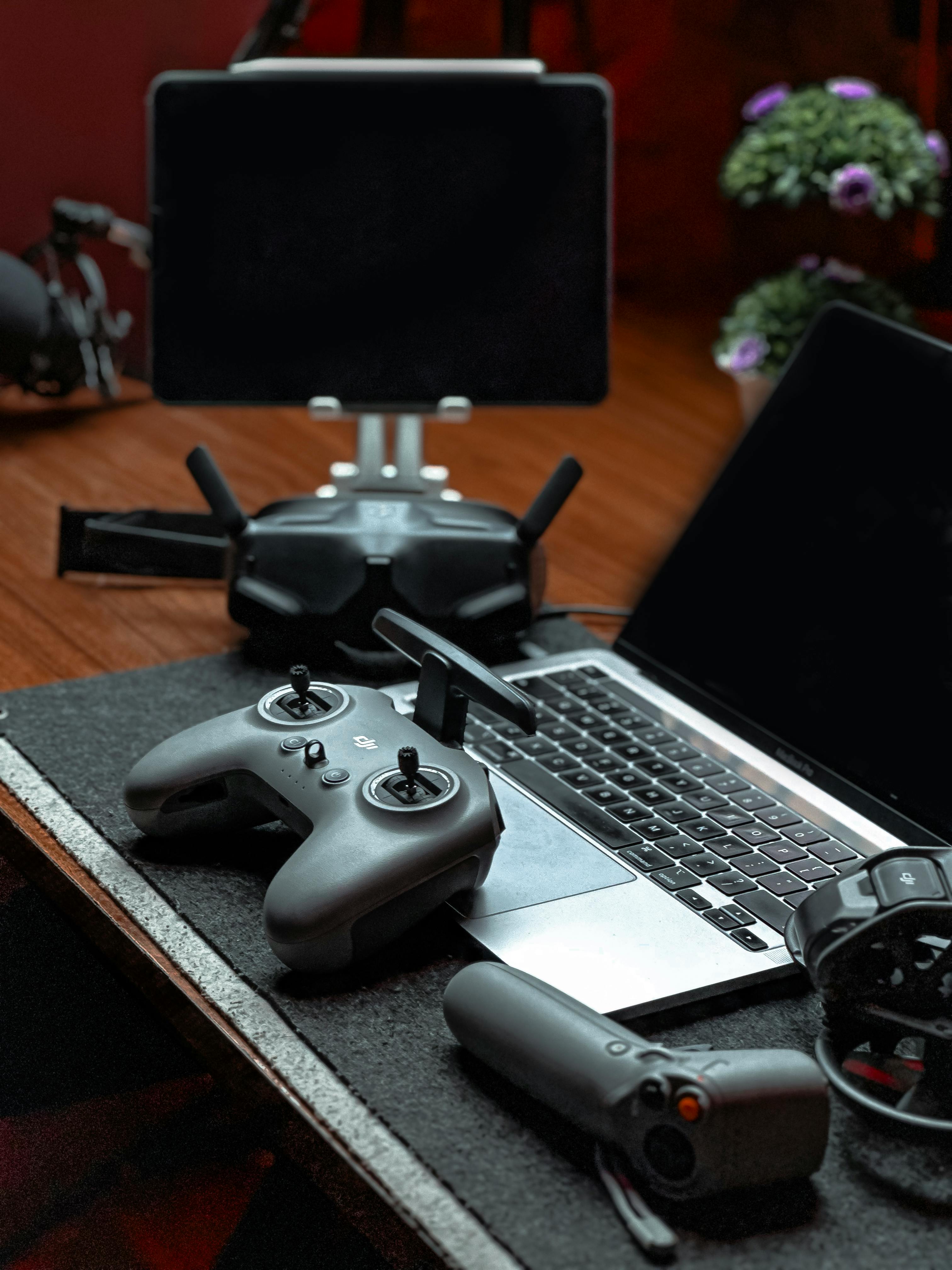 A sleek drone controller setup including a laptop and tablet in a modern office space.