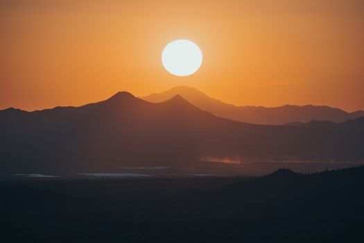 Captivating view of the sunset over the Tucson mountains with vibrant orange hues.