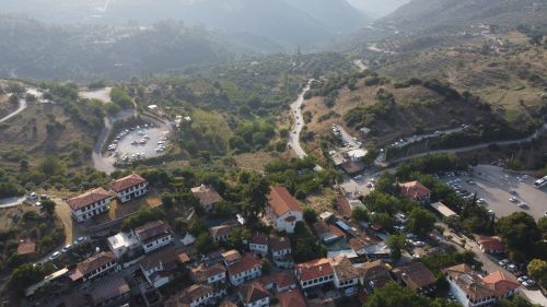 Free Discover the scenic beauty of Şirince village with its charming rooftops and surrounding hills, captured from above. Stock Photo
