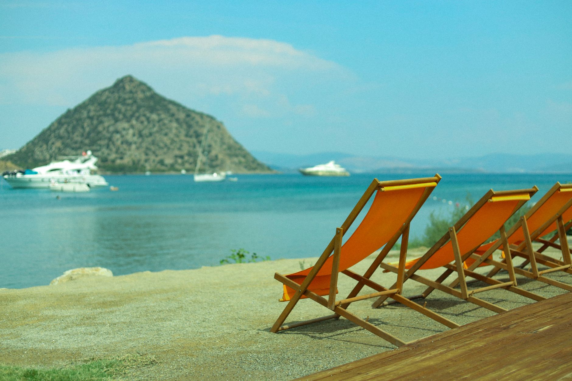 Yunanistan'da bir plajda şezlonglar ve şemsiyeler