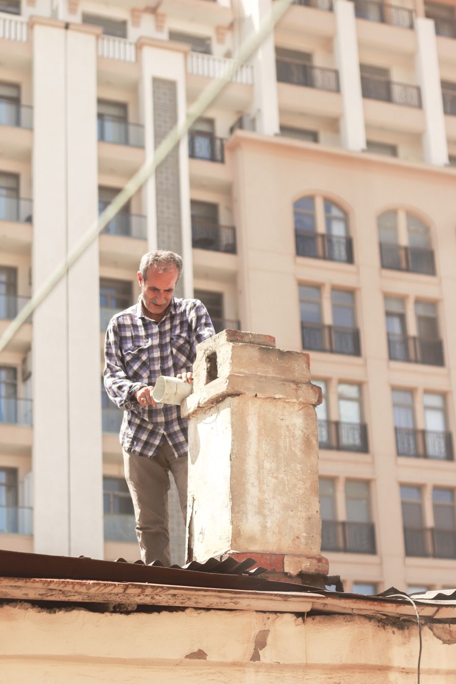 Technician repairing a residential chimney on a rooftop