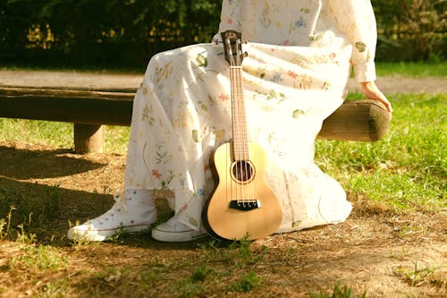 Woman Sitting on a Bench with Guitar