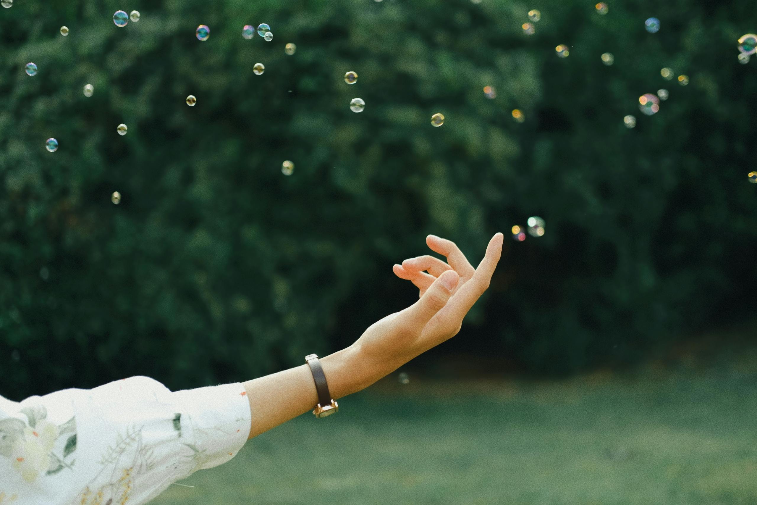 Hand Reaching for Soap Bubbles · Free Stock Photo