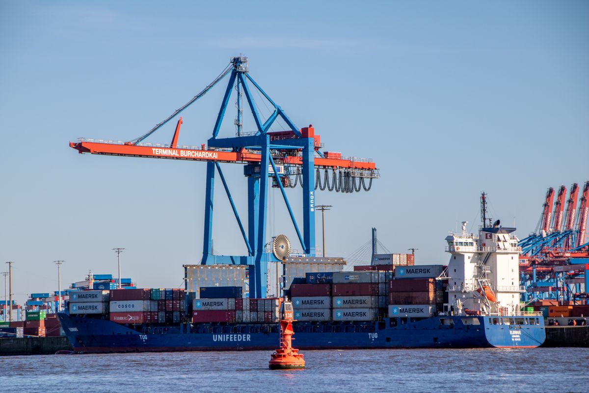 Container ship berthed under gantry cranes at a port terminal