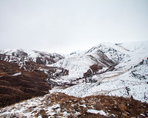 Free A breathtaking view of snow-capped mountains and a winding river in winter. Stock Photo