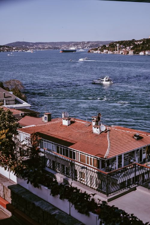 Free A picturesque view of the Bosphorus Strait with red-roofed houses and passing boats. Stock Photo