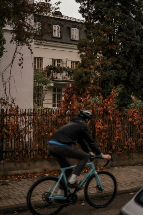 Man in Helmet Riding Bike on City Street