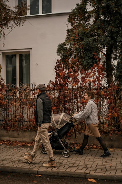 Couple with Stroller Walking on City Street