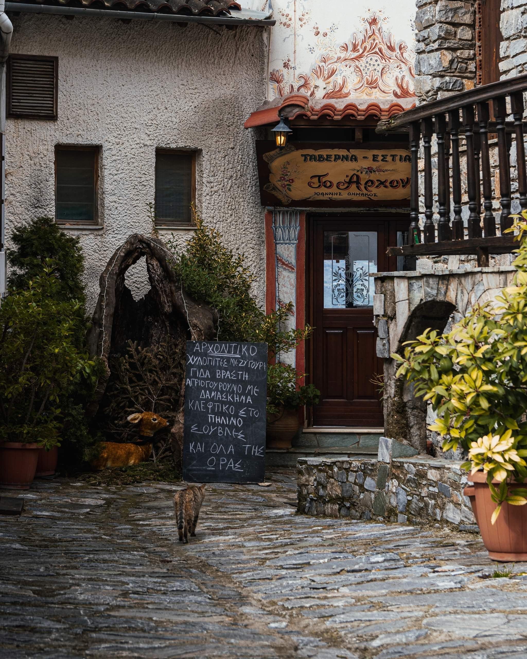 A quaint cobblestone street featuring a rustic entrance to a traditional tavern.