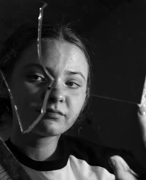 Young Woman Reflecting in Broken Mirror