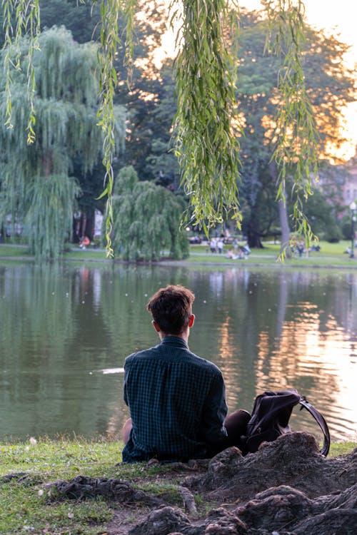 Man Sitting next to Lake